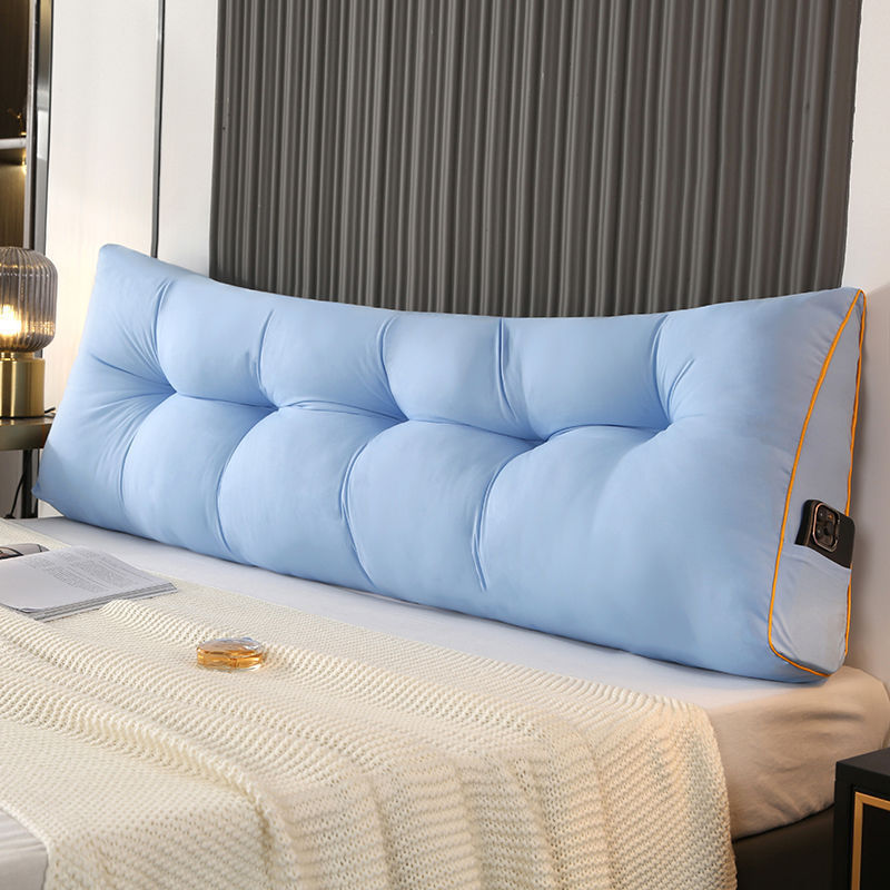 Light blue triangular tufted bed backrest cushion with orange piping and side pocket.