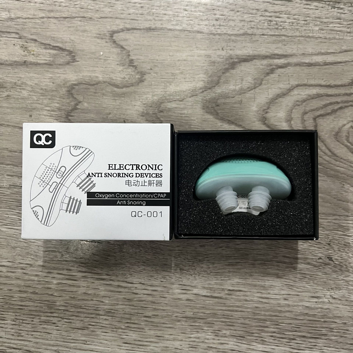 Green electronic anti snoring device with mouthpiece in black presentation box.