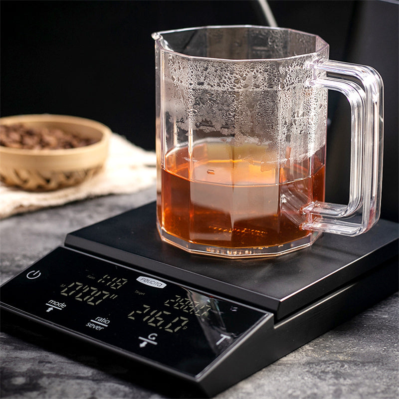 Black coffee electronic scale under a clear glass coffee carafe