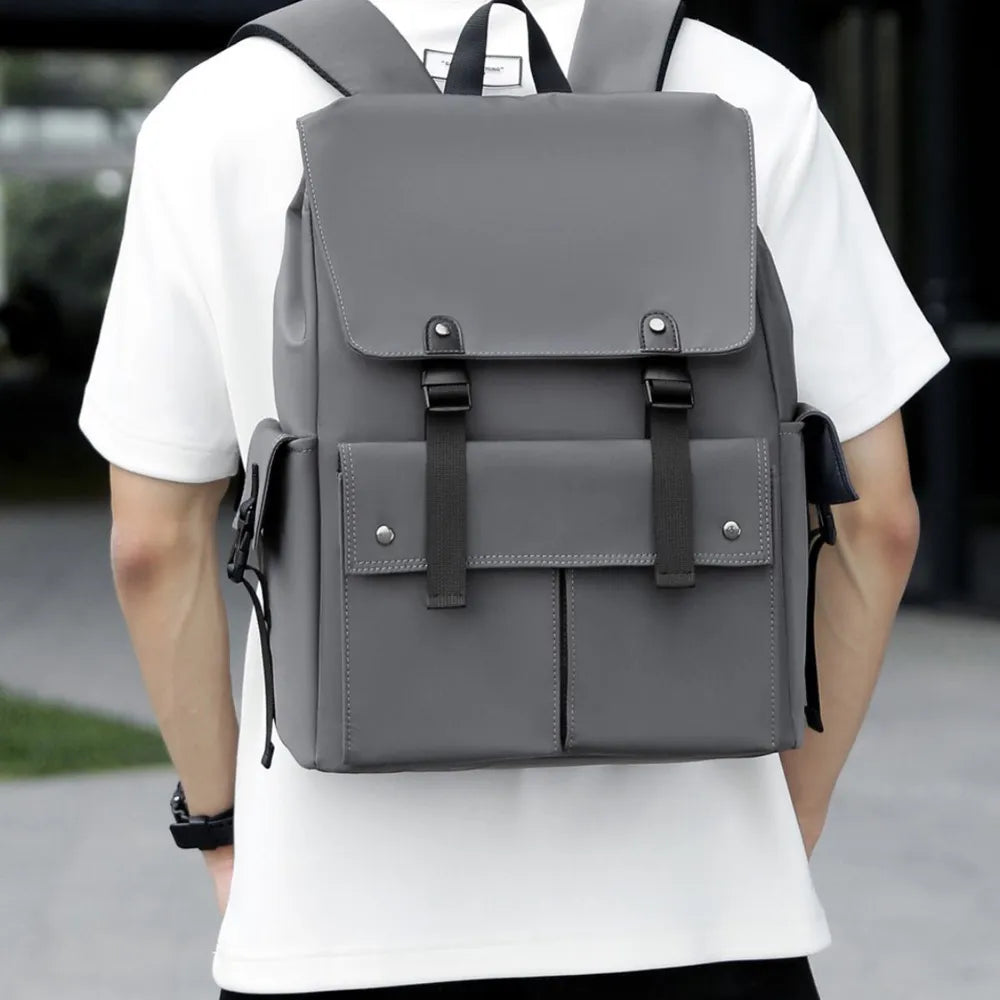 Gray PU leather backpack worn on person, front flap with buckles and two front pocket sectionsshop_this_look_AVdw3f