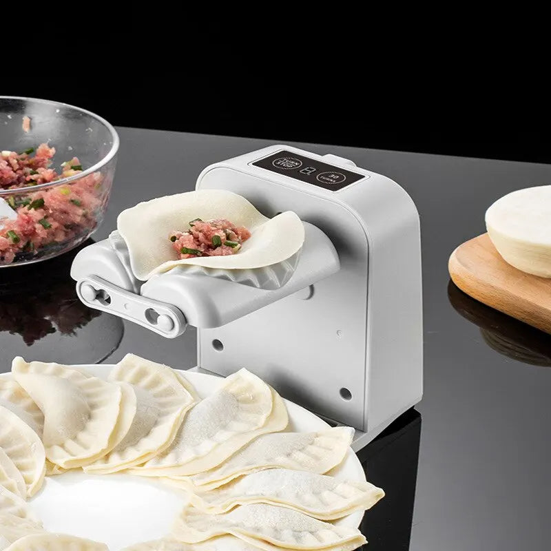 White electric dumpling maker pressing dumpling skins with minced meat filling