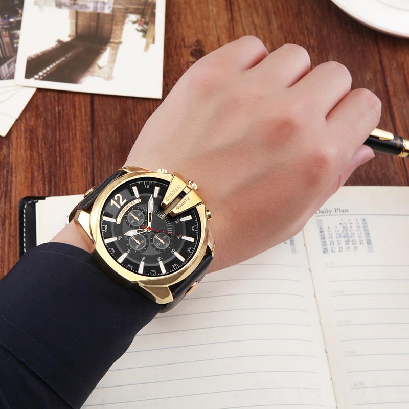 Men's quartz wristwatch on wrist with black dial and gold-tone case