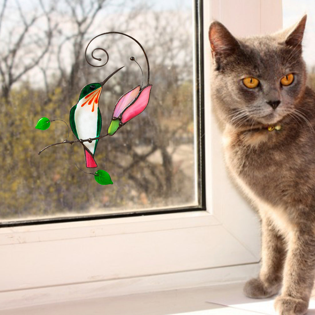 Cartoon bird window decal with green, orange and pink birds on a swirling branch design