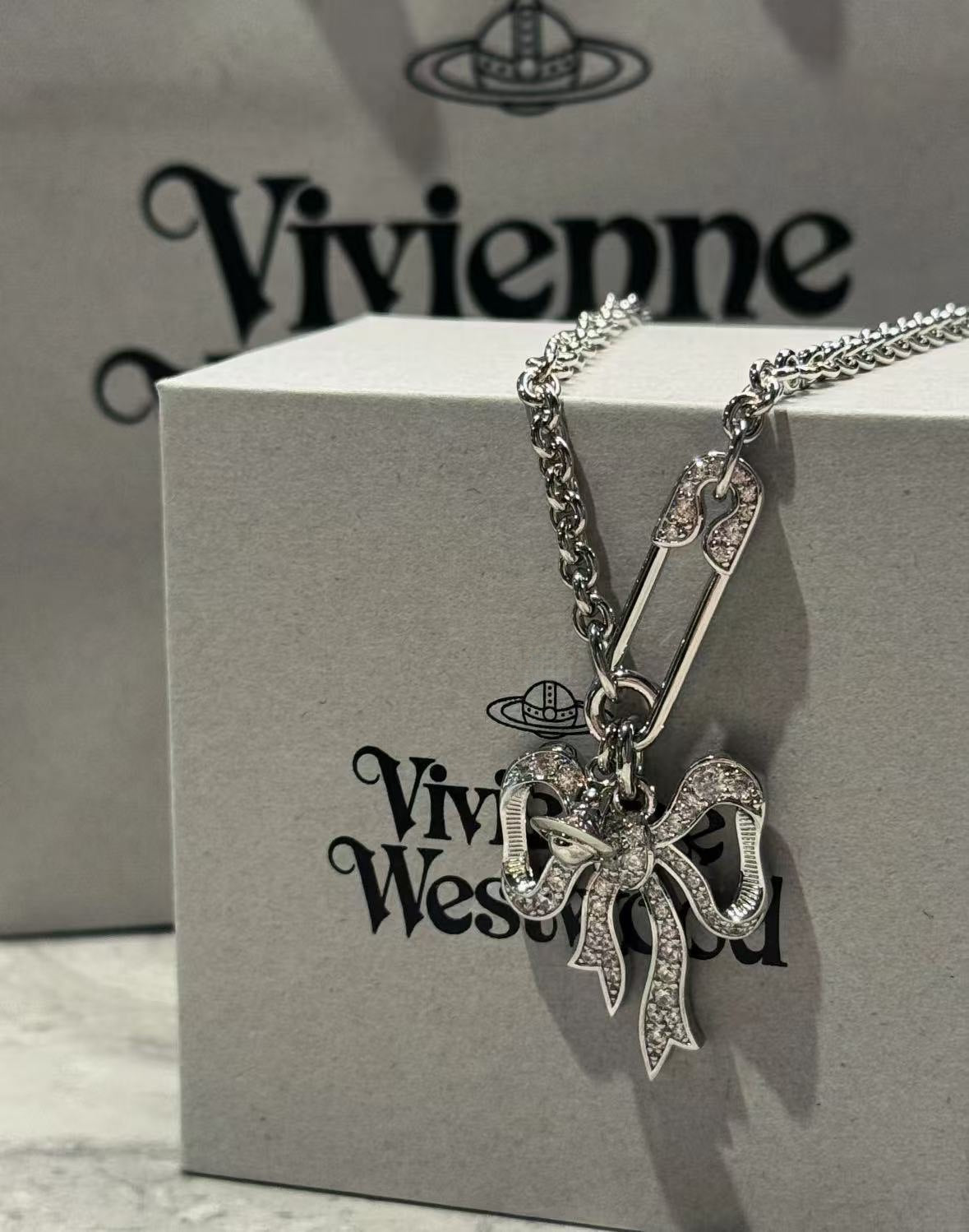 Silver bow pendant charm necklace on Vivienne Westwood gift box