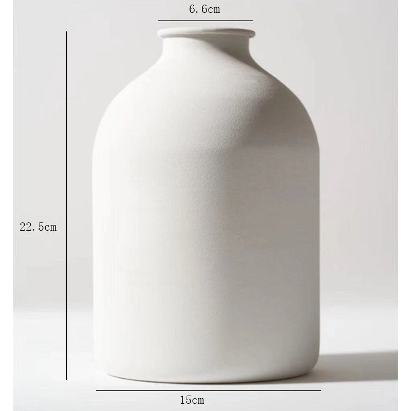 Matte white metal vase with rounded body and short neck opening
