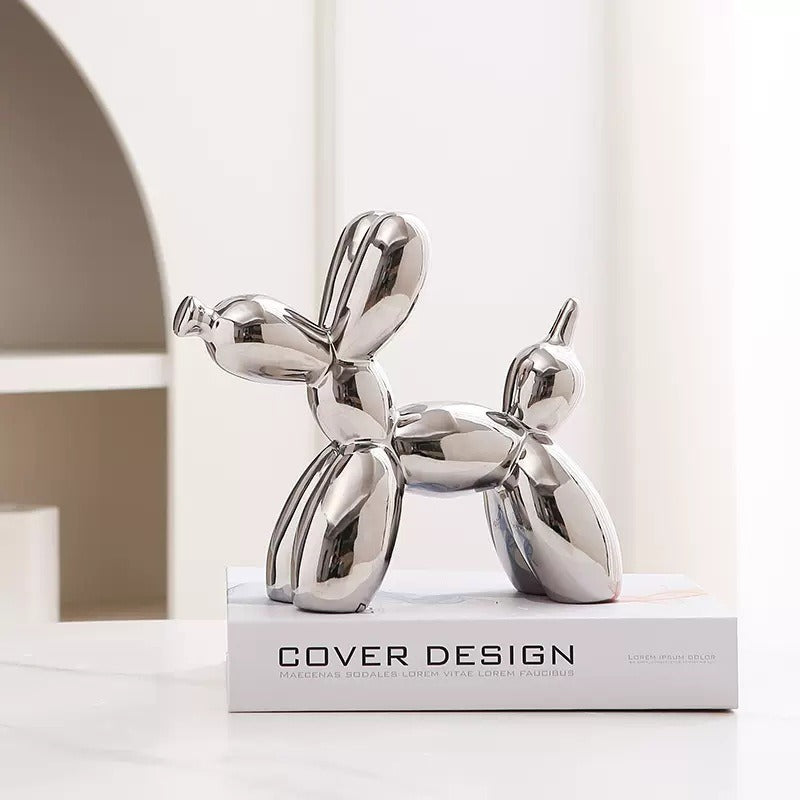 Silver chrome balloon dog figurine with upright ear detail on a pedestal