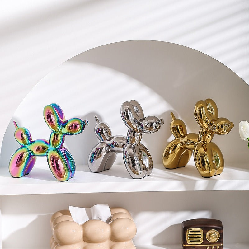 Multicolored, silver, and gold balloon dog figurines on a curved shelf