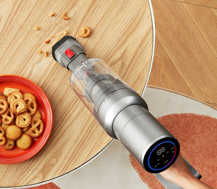 Cordless handheld vacuum on wood floor, gray canister and blue control display