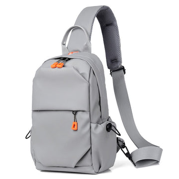 Gray crossbody sling backpack bag with orange zipper pulls and adjustable shoulder strap