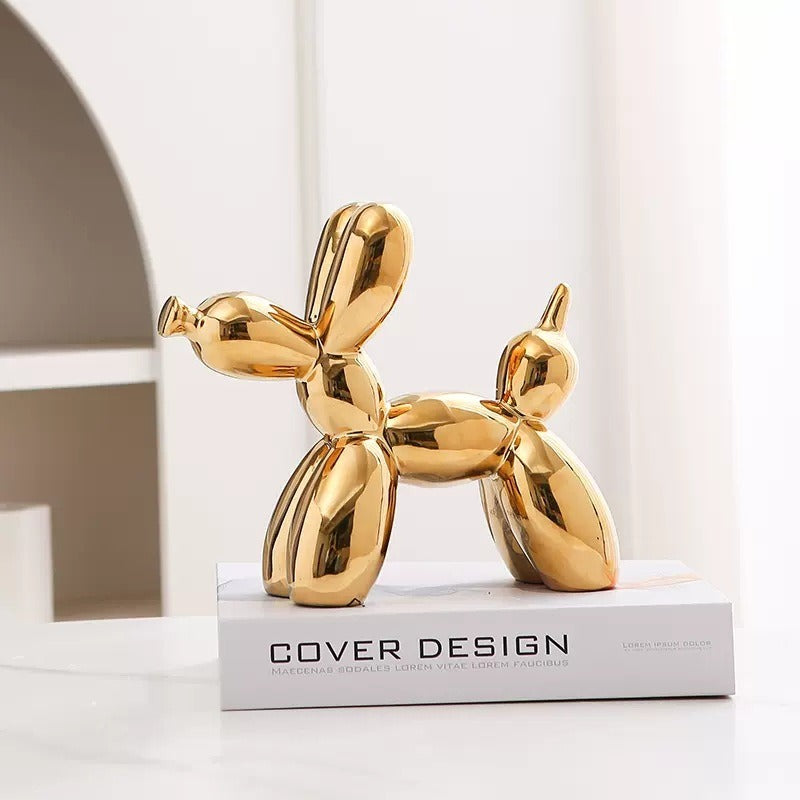 Gold balloon dog figurine with reflective surface on a pedestal