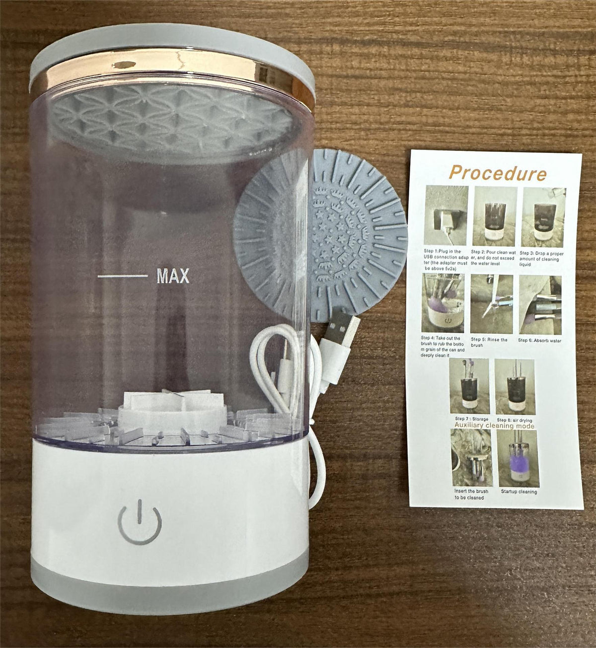 Electric brush cleaner with open clear reservoir, power cable, and gray scrubbing plate