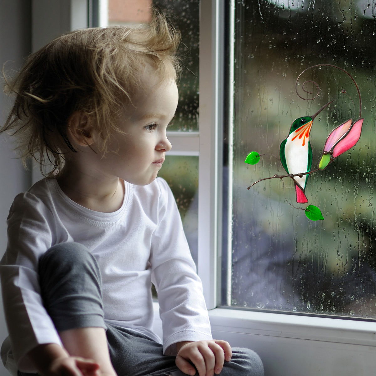 Cartoon bird window decal with green leaves and orange pink birds on a curved branch