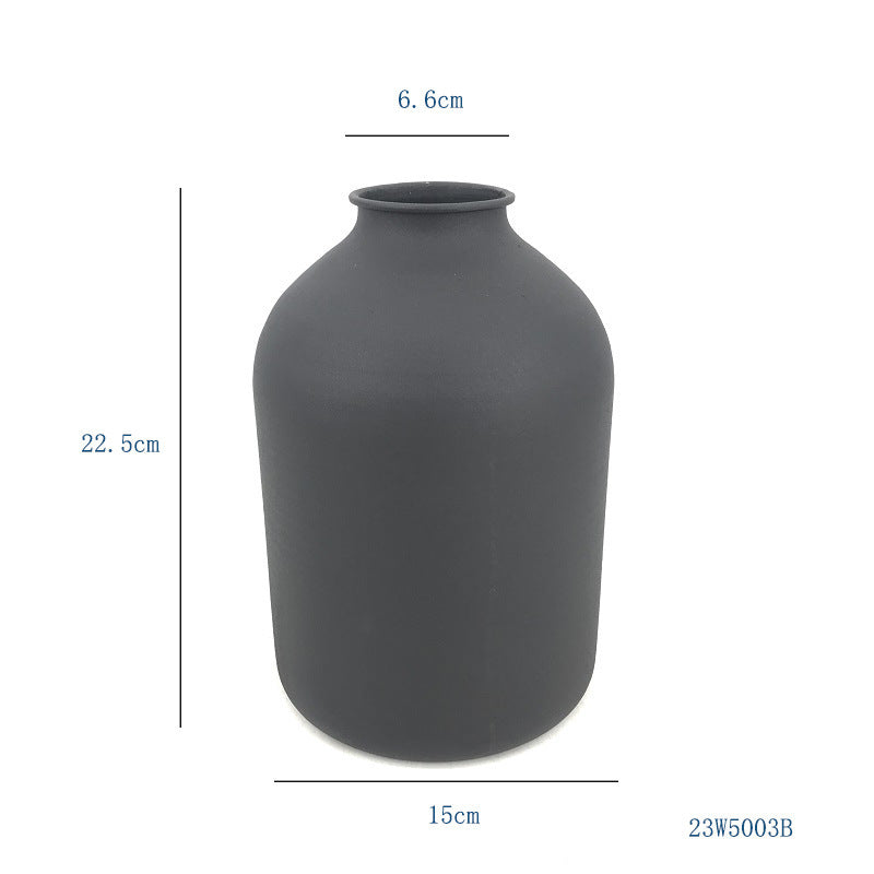 Matte black metal vase with rounded bulb shape and short top opening