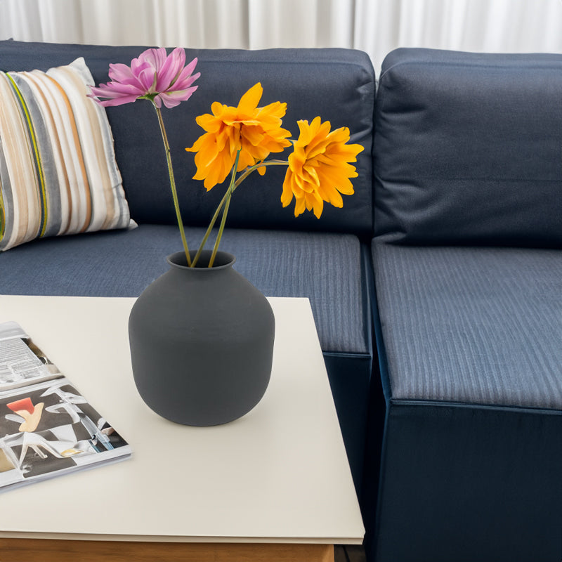 Matte black metal vase with rounded body, holding yellow and pink dried flowers